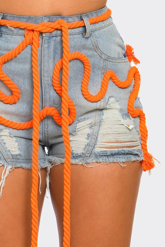 Playful denim shorts with orange drawstring - model wearing frayed hem shorts