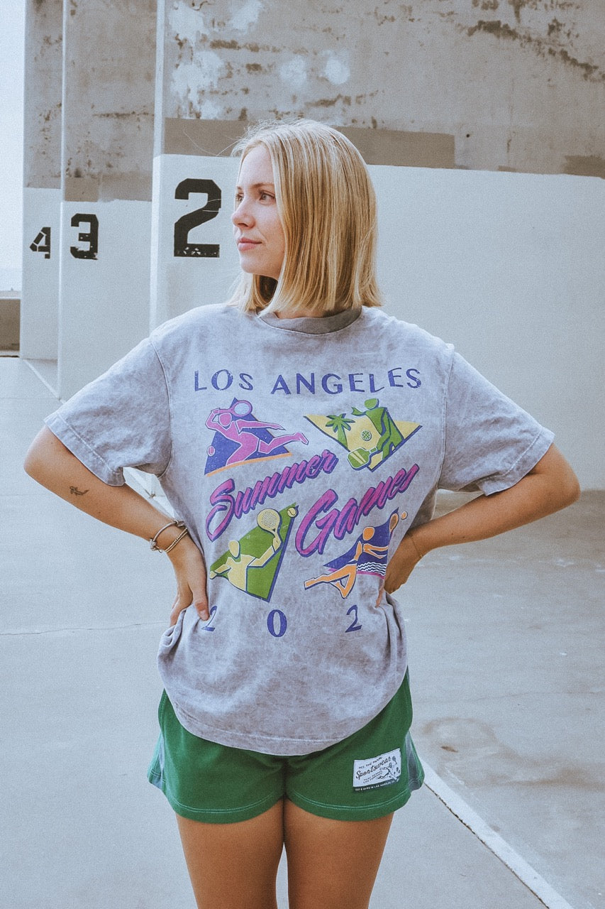 Woman wearing a 'Los Angeles Summer Games' t-shirt in an outdoor setting.