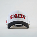 White cap with red and black "Aztec" upside down text on a light gray background