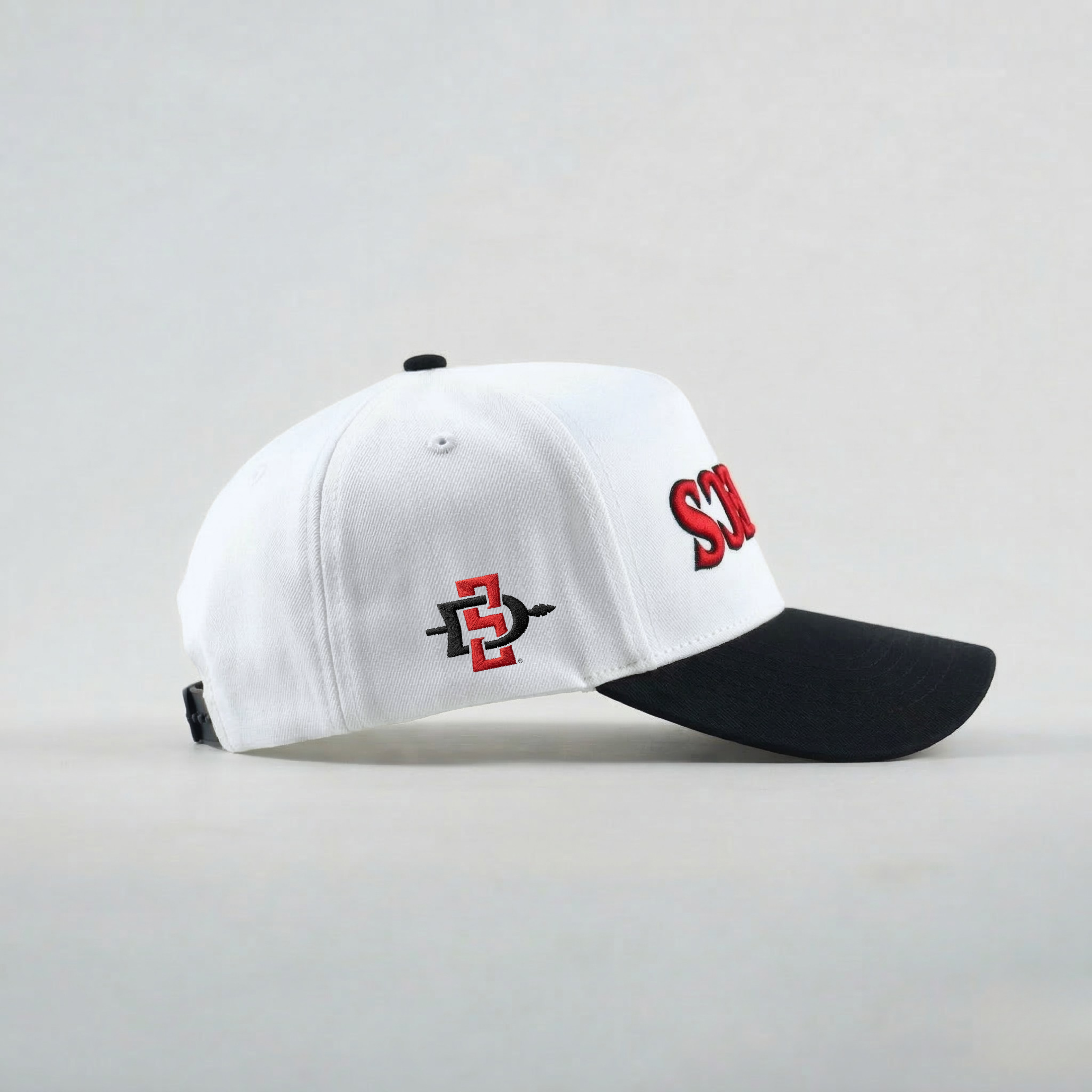 White and black cap with red and black logo on a light gray background