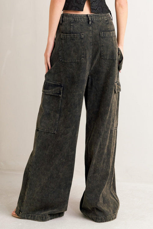 Dark denim cargo pants worn by a person on a plain background