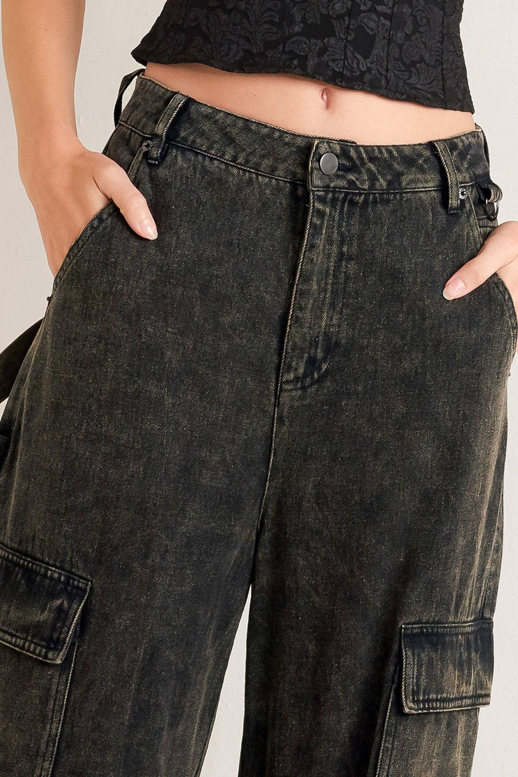 Person wearing black cargo pants with a neutral background