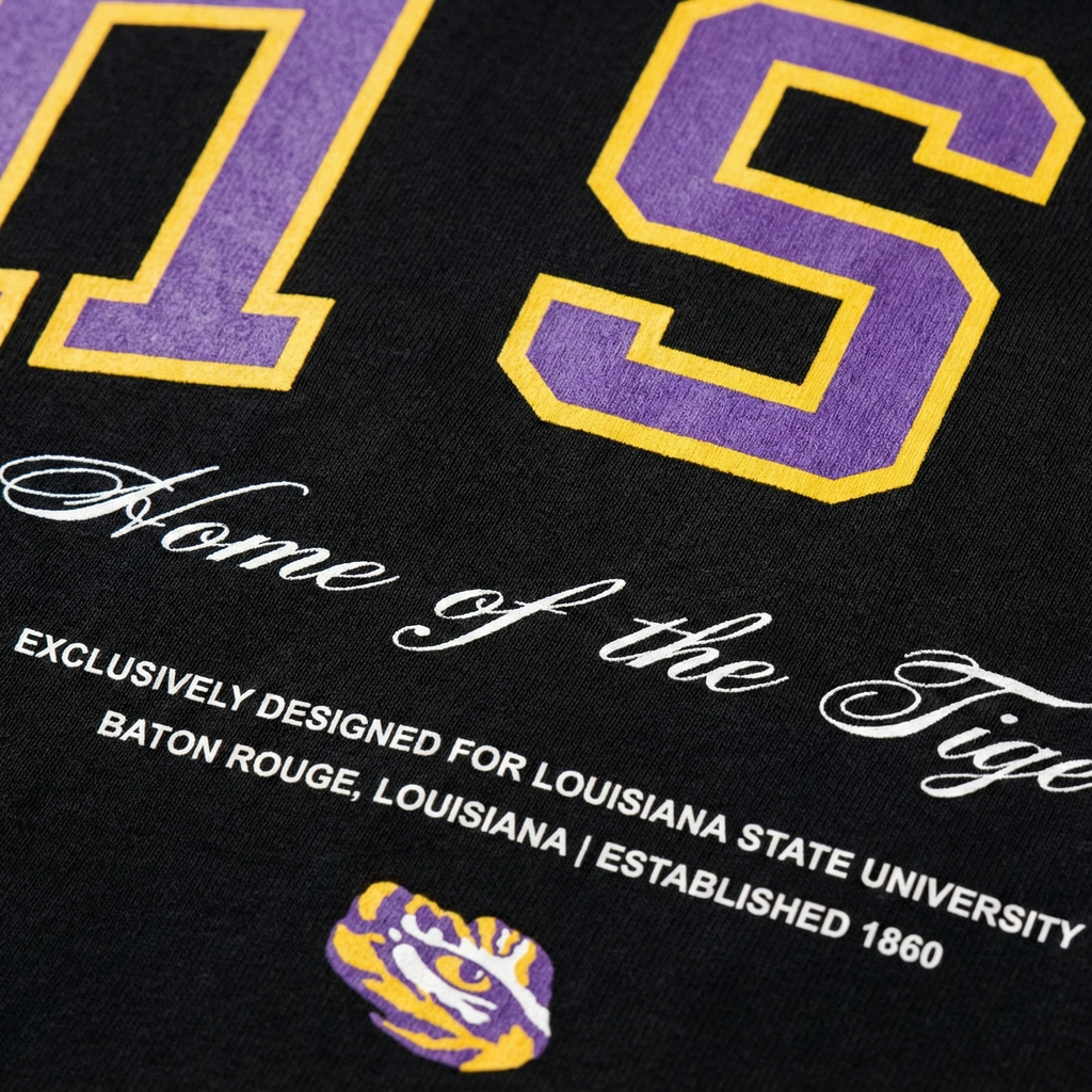 Black shirt with purple and gold text and logo, featuring 'Home of the Tigers' and LSU branding.