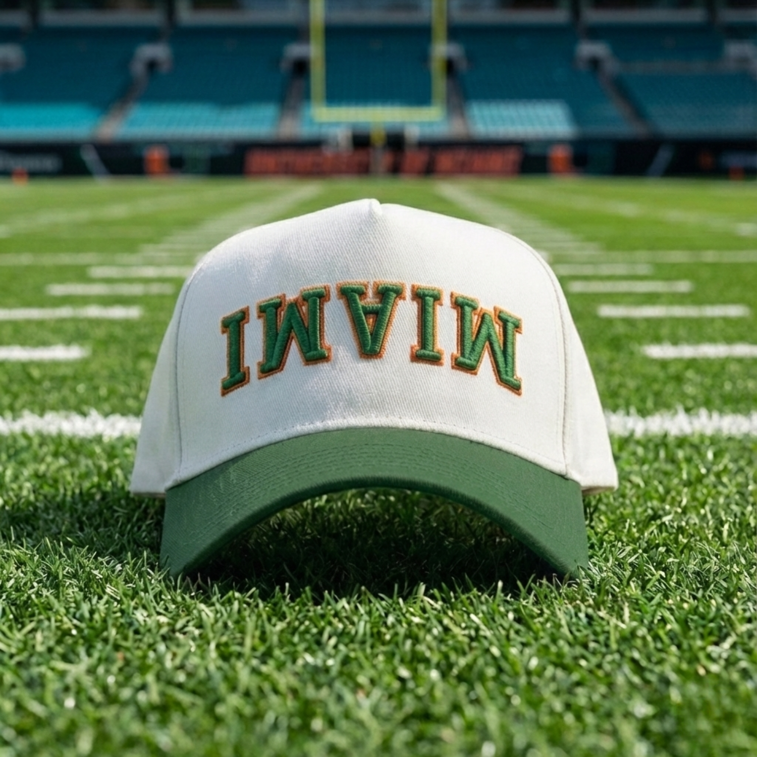 White cap with 'MIAMI' on a football field