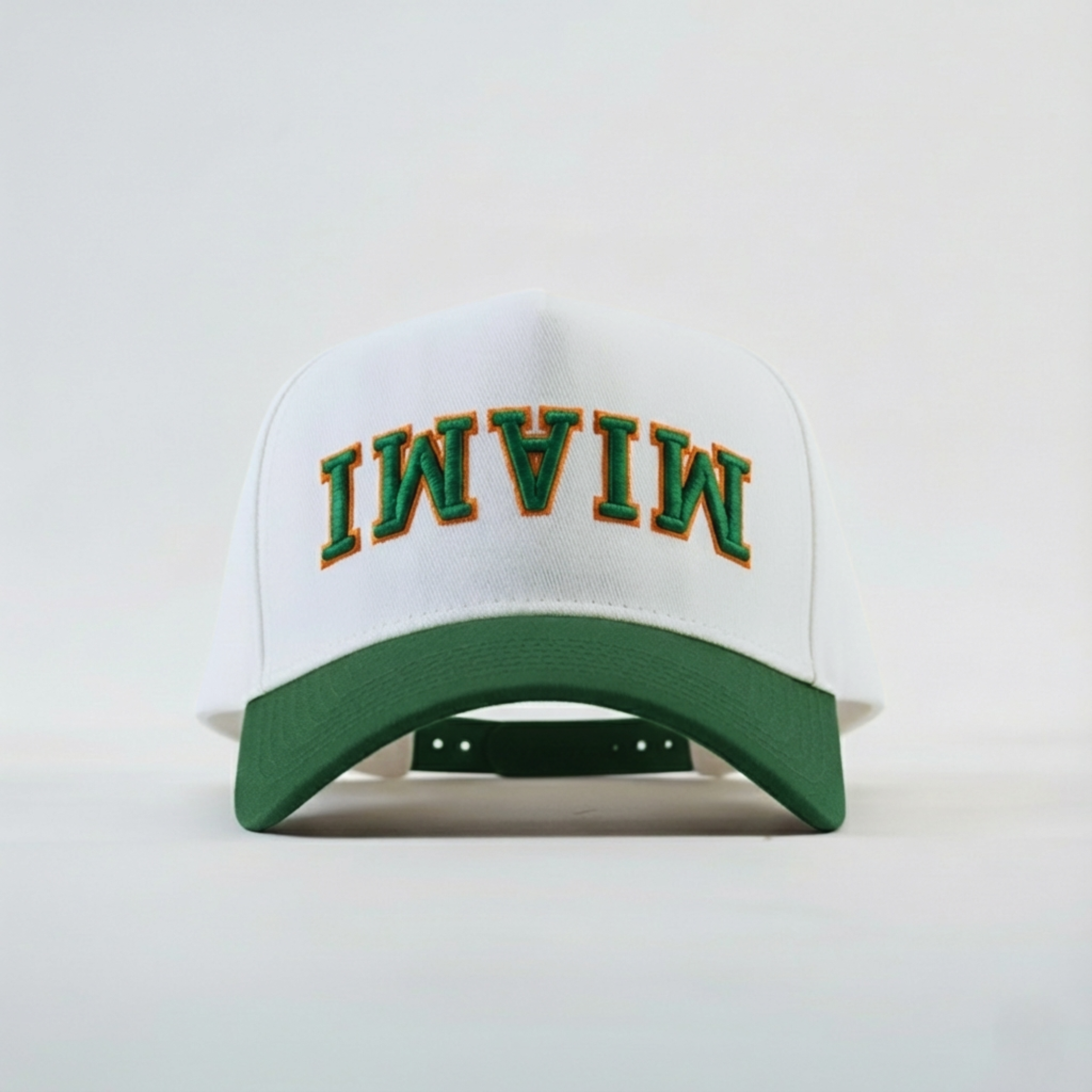 White cap with green brim and 'MIAMI' text on a white background