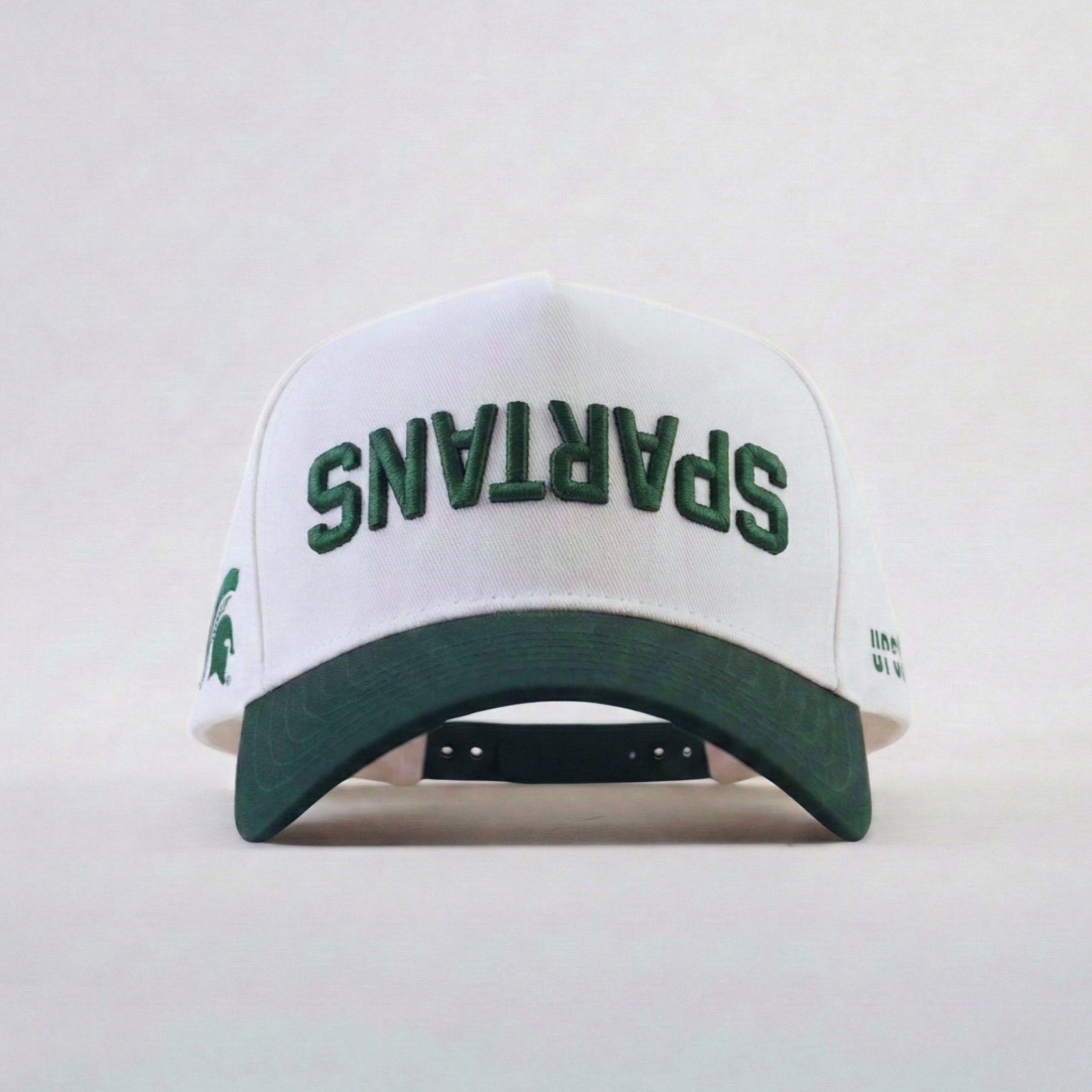 White cap with green text 'SPARTANS' on a light gray background