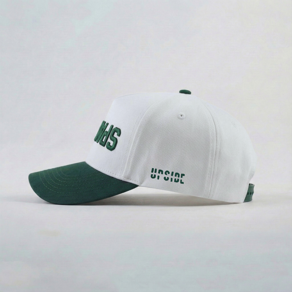 White cap with green brim and text on a light gray background