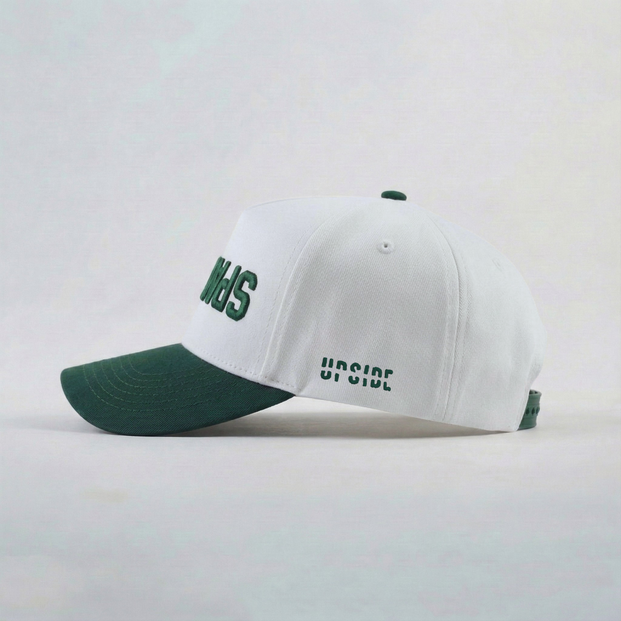 White cap with green brim and text on a light gray background