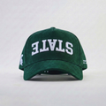 Green cap with 'STATE' upside down embroidered on a white background