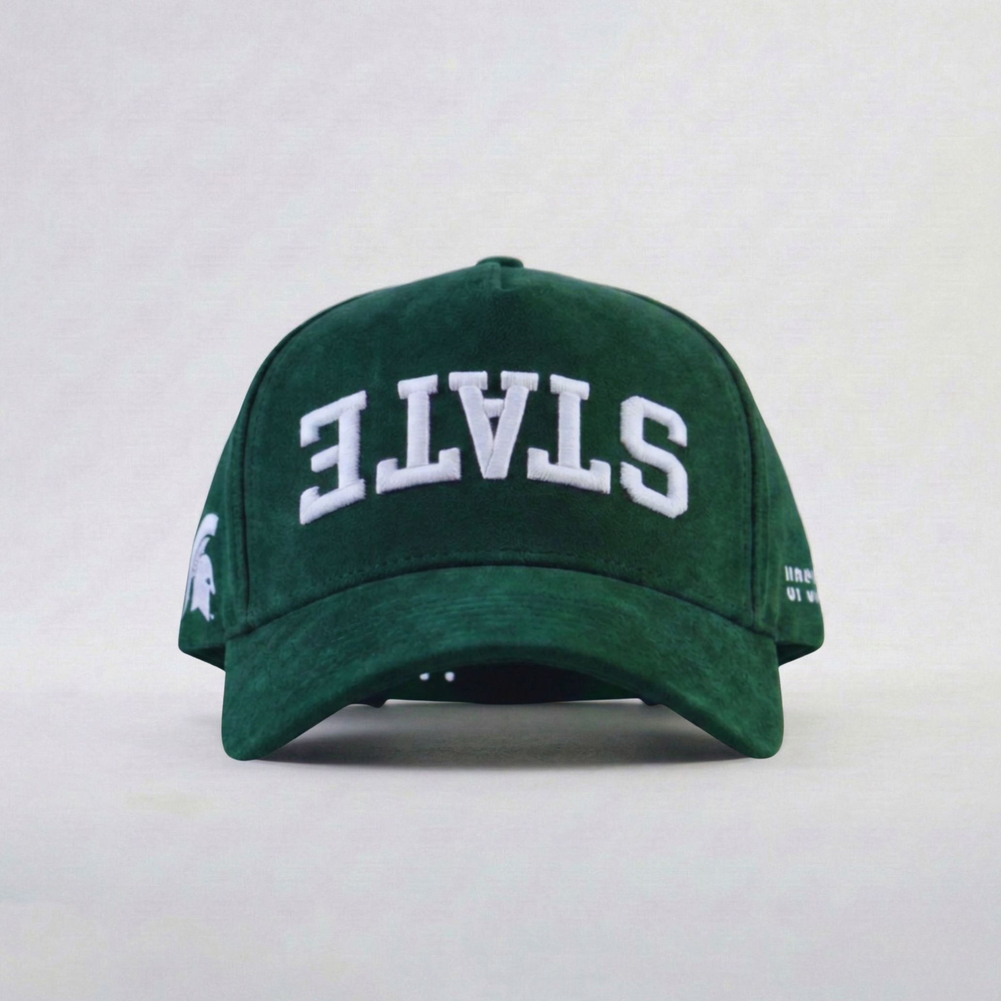 Green cap with 'STATE' upside down embroidered on a white background