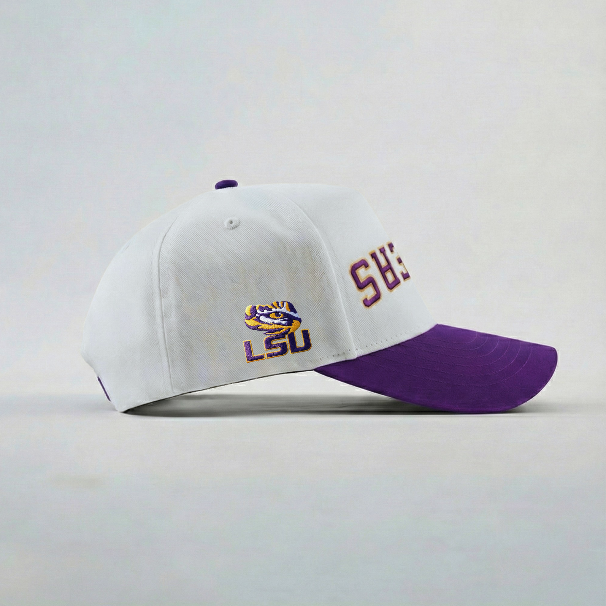 White and purple baseball cap with LSU logo on a light gray background