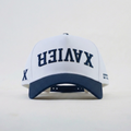 White cap with blue brim and upside-down "Xavier" text on a light gray background